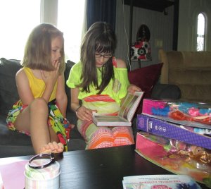 Jordan reading her new pony book and Jaycie listening intently