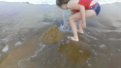 Jaycie digging in the sand despite the water.